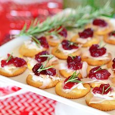 small appetizers with cranberry toppings are displayed on a platter