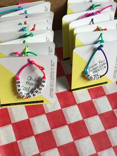 several bracelets with words on them sitting on top of a checkered table cloth