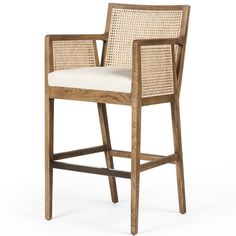 a wooden and wicker bar stool with white upholstered cushion on the seat