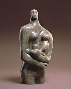 a sculpture of a woman holding a baby in her arms, on a brown background