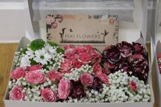 two boxes filled with flowers on top of a wooden table