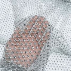 a pair of pink and silver shoes on top of a white cloth covered in sequins