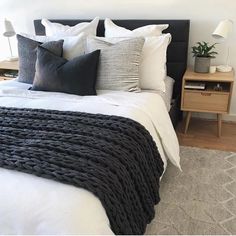 a black and white bed in a bedroom with two nightstands next to the bed