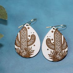 Introducing our beautiful Cactus Dangle Drop Earrings file, perfect for adding a touch of southwestern charm to your jewelry collection. These earrings feature delicate cactus-shaped elements that dangle gracefully from your ears, adding a unique and eye-catching accent to any outfit. Laser cut this file using a laser machine and use your favorite materials to create earrings that are lightweight, comfortable, and perfect for all-day wear. The intricate design and attention to detail make these Southwestern Engraved Jewelry For Festivals, Southwestern Style Metal Earrings For Gift, Southwestern Style Metal Drop Earrings, Southwestern White Teardrop Earrings, Desert Earrings, Leather Cactus Earrings, Nickel-free Southwestern Teardrop Earrings For Gifts, Western Cactus Earrings, Earring Art