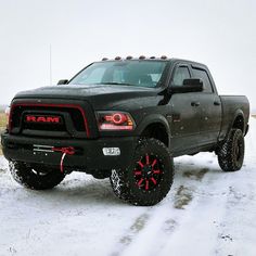 a black ram truck parked in the snow