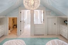 a bedroom with two beds and a chandelier hanging from the ceiling above it