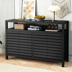 a black cabinet with shutter doors on the bottom and shelves below it in a living room