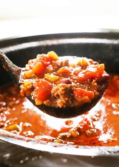 a spoon full of chili and meat soup