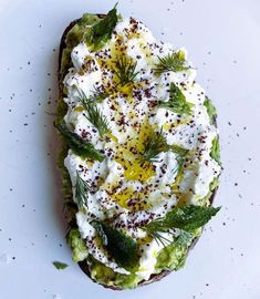 a piece of bread topped with whipped cream and green garnish on top of it