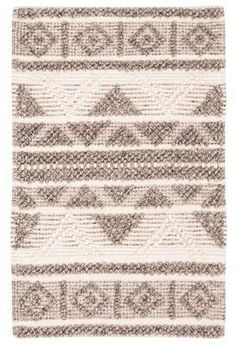 a beige and white rug with geometric designs