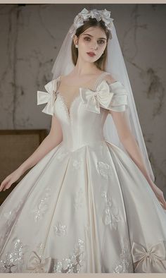 a woman in a wedding dress with a veil over her head and flowers on it