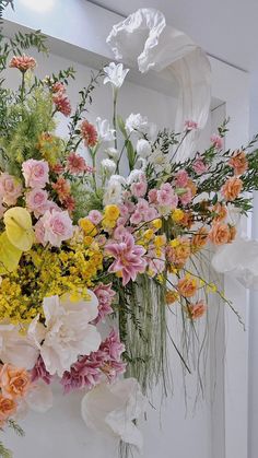 a vase filled with lots of different colored flowers