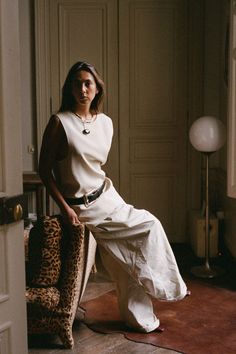 a woman sitting on top of a leopard print chair