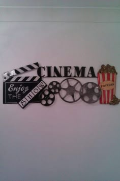 there is a sign that says cinema and some movies are on the wall behind it