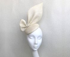 A classic and sophisticated ivory oversized bow headpiece. Perfect for any wedding or Royal Ascot (meets Royal Enclosure size regulations) or that finishing touch for your special occasion.  Discount if you go to my web site  - rubybose.com message me there  The disc is approx 16 cm in diameter and stands about 25cm high Secured with elastic or a satin covered hairband in a choice of colours to blend your hair colour. I recommend elastic with this shape.  Each piece is handmade by me for you, using the highest quality materials which takes about 5 days, if you have a specific date you need the headpiece please get in touch and I will ensure you receive in good time. If you would like the piece to be made to match your outfit, or adapted please contact me (a swatch can be sent or matched to Classic Beige Hat For Wedding, Classic Beige Wedding Hat, Elegant Wedding Hats With Satin Bow, Wedding Hats With Bow And Short Brim, Elegant Cream Hat With Bow, Elegant Wedding Hat With Bow, White Bow Fascinator For Wedding, Wedding Fascinator With Satin Bow, Wedding Fascinator With Fitted Satin Bow