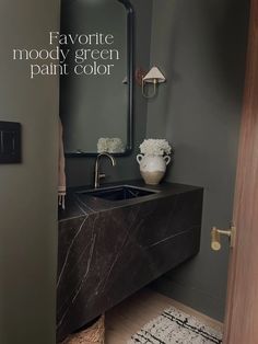 a bathroom sink sitting under a mirror next to a wooden cabinet and counter with flowers on it