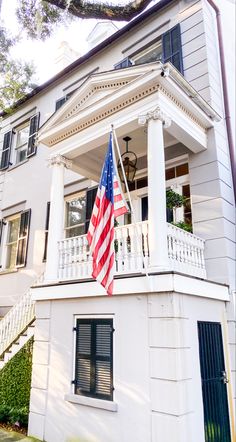 an american flag on the porch of a white house