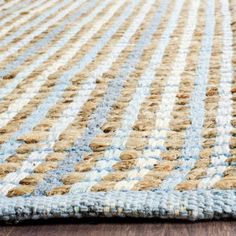 a blue and beige rug on top of a wooden floor