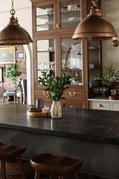 a kitchen with an island and two hanging lights over the top of it's counter