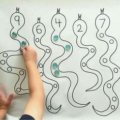 a person drawing on a white board with numbers and shapes in the shape of waves