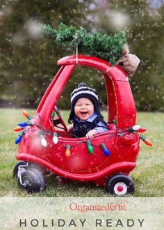 a small child in a red car with christmas lights