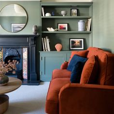 a living room filled with furniture and a fire place in front of a book shelf