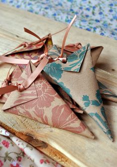 four pieces of paper are tied together and placed on a wooden board with floral designs