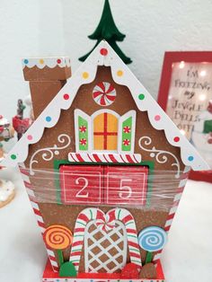 a gingerbread house made out of cardboard with candy and candies on the front