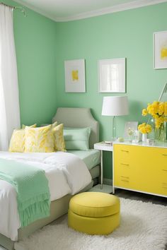 a bedroom with green walls and white carpeted flooring, yellow accents on the bed