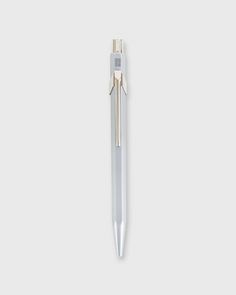 a pen that is sitting on top of a white surface and has a silver tip