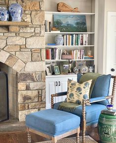 a living room filled with furniture and a fire place in front of a stone fireplace