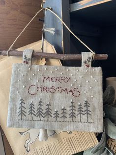 a merry christmas sign hanging from a wooden pole next to other decorations and items on a table