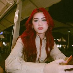 a woman with red hair sitting at a table