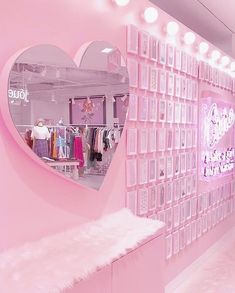 a pink room with a heart shaped mirror on the wall