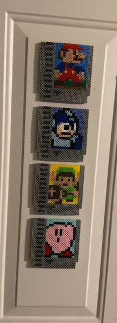 four lego magnets are hanging on the front door to look like mario and luigi