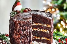 there is a large piece of chocolate cake on the table with christmas decorations around it