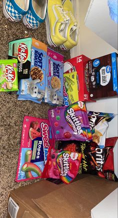 a pile of snacks sitting on top of a carpeted floor next to a shoe box