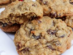 several oatmeal cookies with cranberries are on a white paper plate