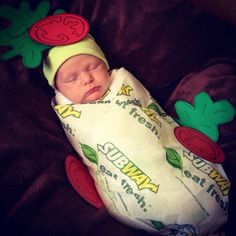 a baby wearing a hat and sleeping on a blanket