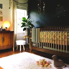 a baby's room with a crib, chair and rug on the floor