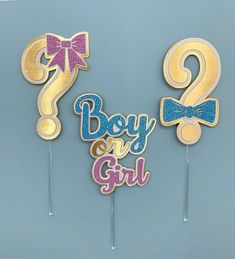 two cake toppers that say boy and girl with bows on them, one has the number 2