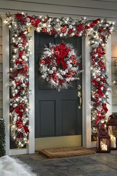 a christmas wreath on the front door of a house decorated with red and silver ornaments