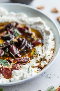 a bowl filled with hummus and olives on top of a table