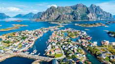 an aerial view of the town of lofo, norway with mountains in the background