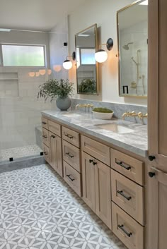 a bathroom with double sinks and two mirrors on the wall next to a walk in shower