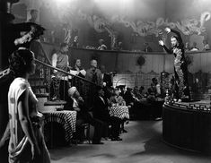 a group of people standing around in front of a stage with clowns on it