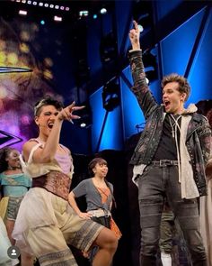 two men and one woman are dancing on stage