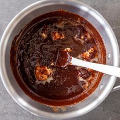 a pot filled with sauce and meat on top of a table