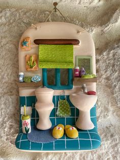 a toy bathroom with toilet, sink and mirror