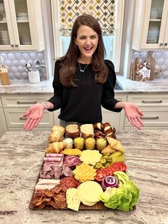 a woman standing in front of a tray of food